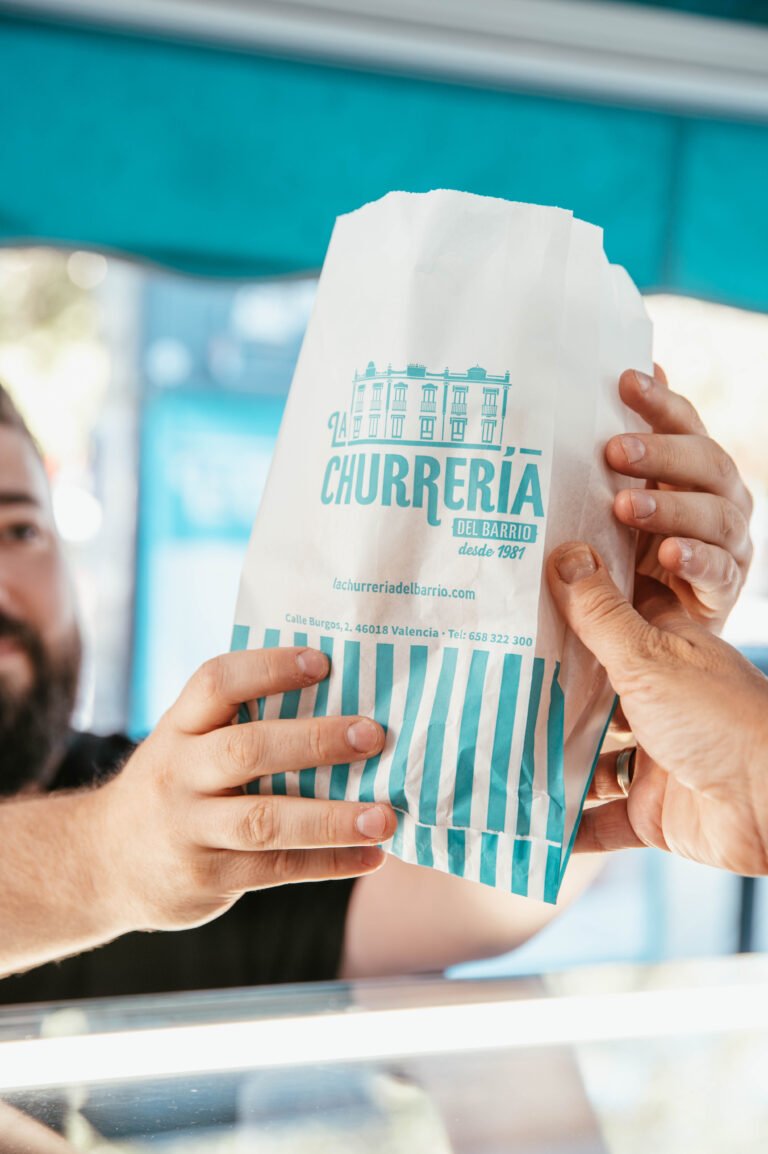 Manos sosteniendo una bolsa de churros de La Churrería
