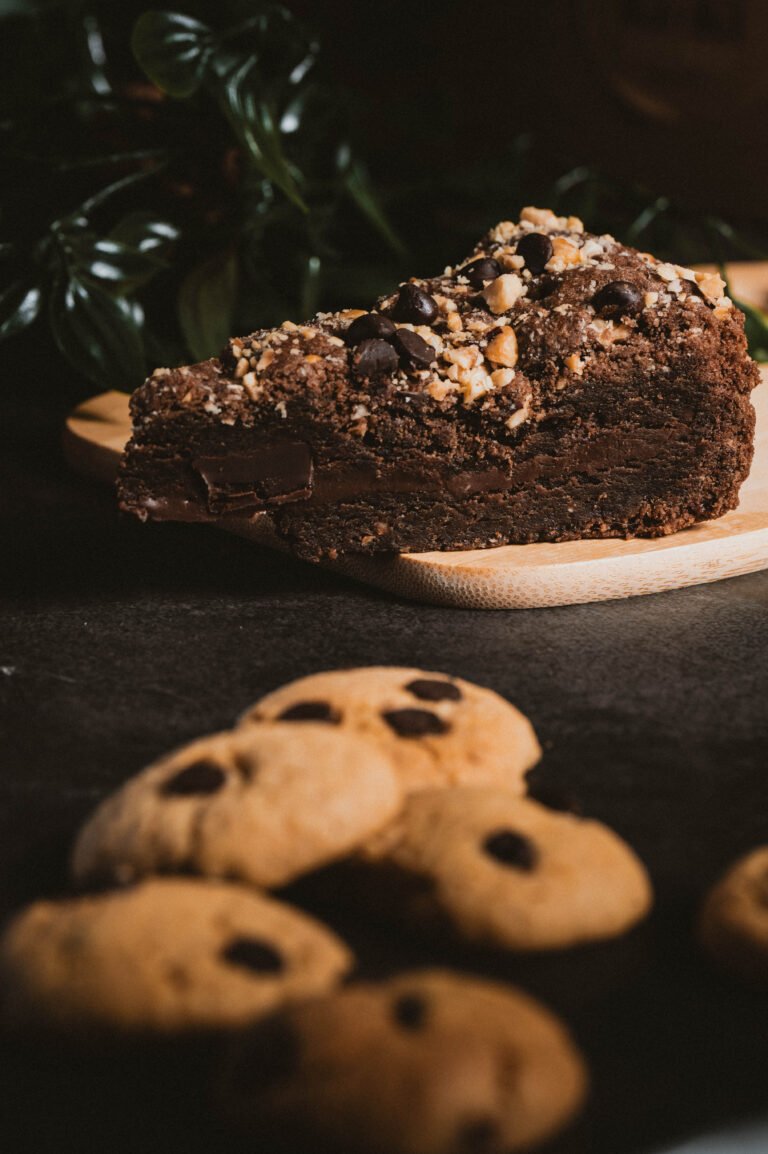 Trozo de tarta de chocolate junto a galletas con pepitas