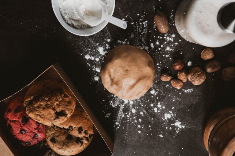 Masa de galleta y cookies con frutos secos sobre una mesa oscura