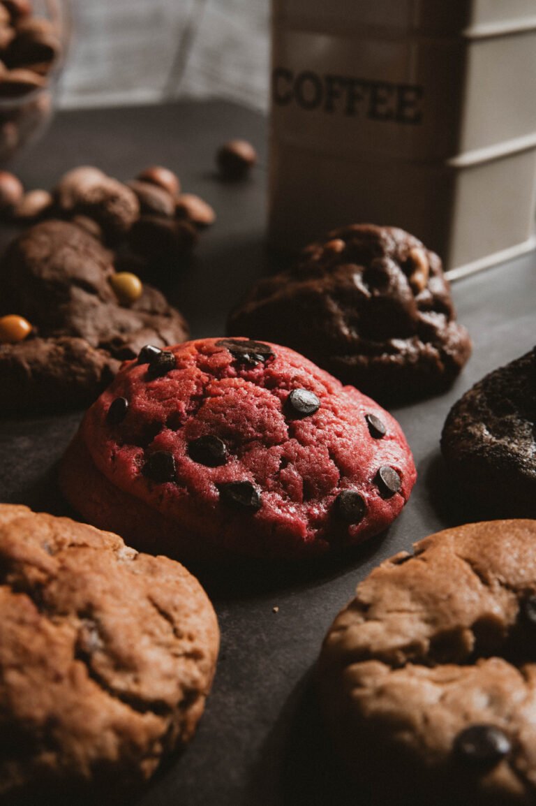Galletas de chocolate y de color rosa sobre una mesa oscura