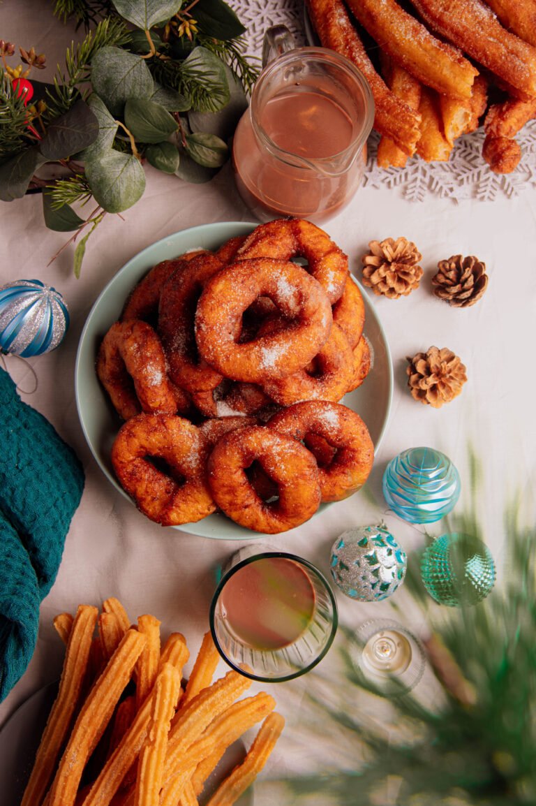 Churros y rosquillas servidos sobre una mesa, vista cenital