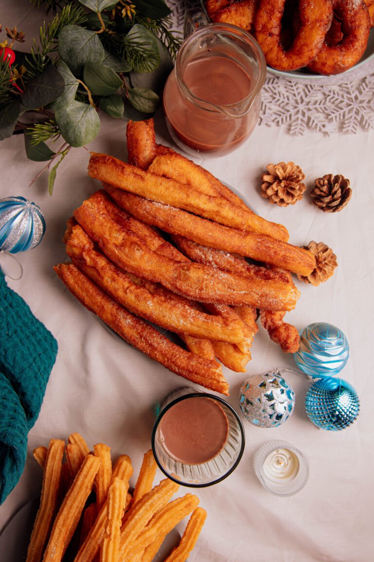 Plato de churros con un vaso de chocolate