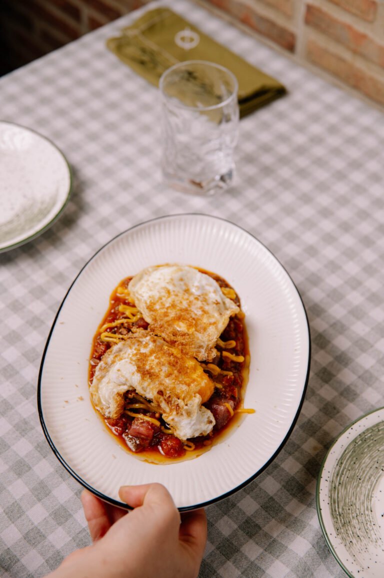 Huevos fritos con salsa servidos en un plato ovalado