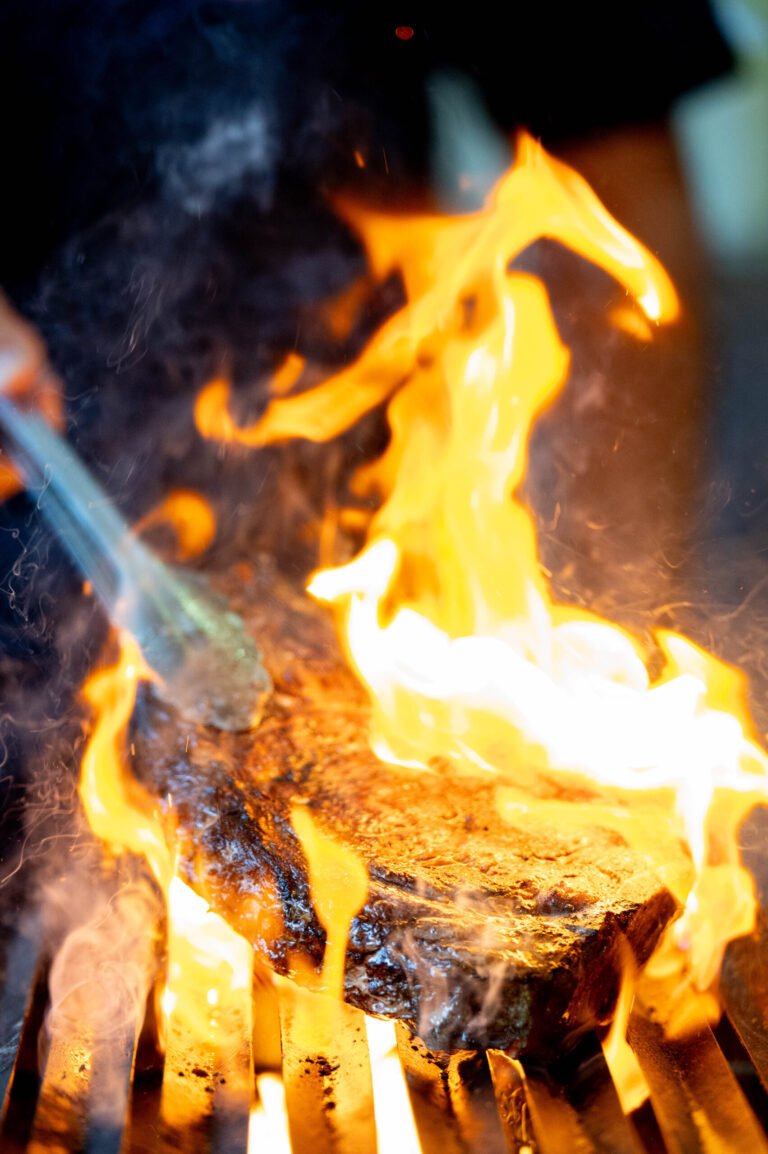 Llamas sobre un chuletón en la parrilla