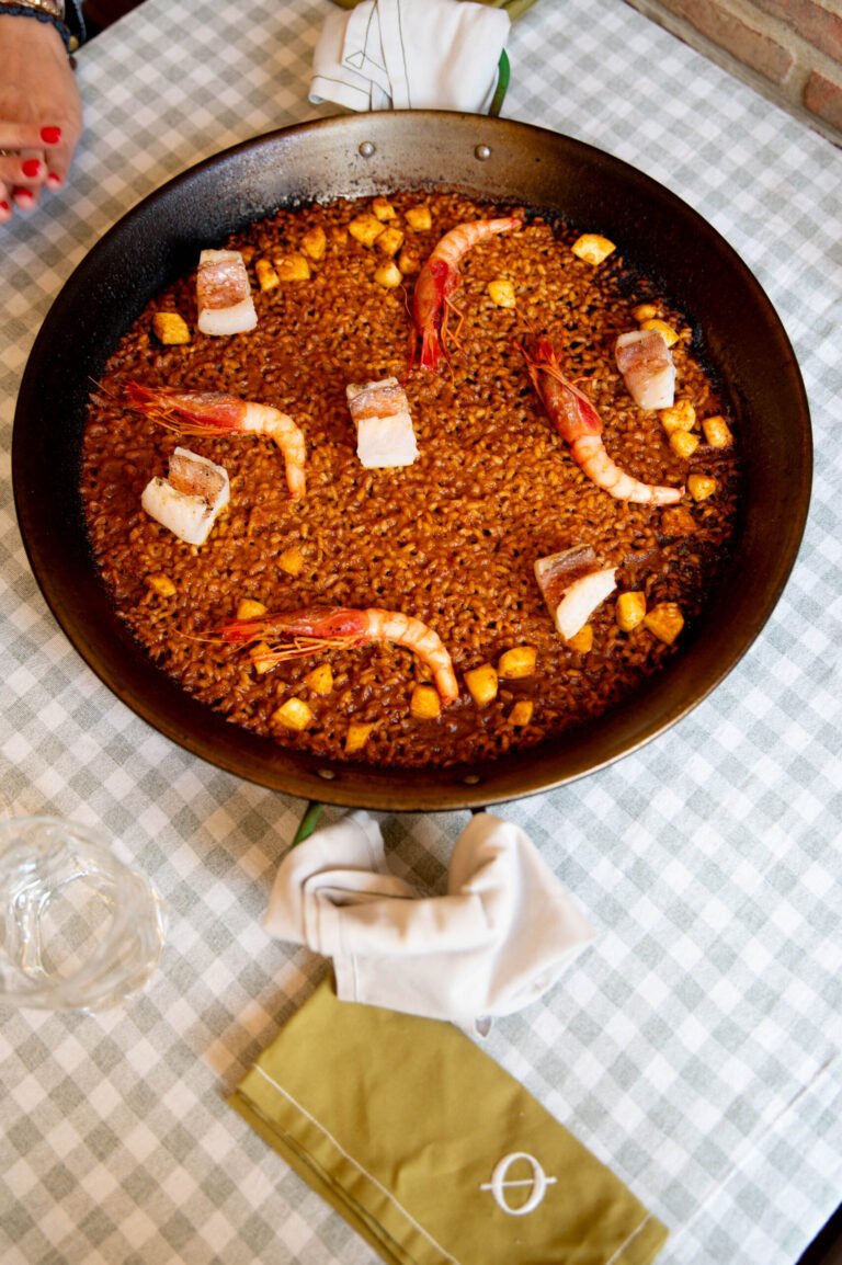 Paella en sartén sobre un mantel de cuadros