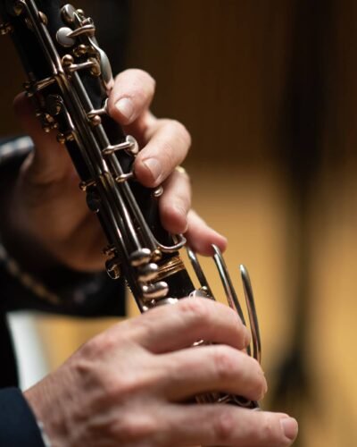 Manos tocando un clarinete, detalle