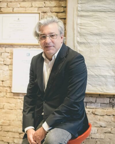 Retrato corporativo de un empresario con americana ante una pared de ladrillo