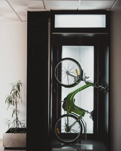 Bicicleta verde colgada en el escaparate de una tienda