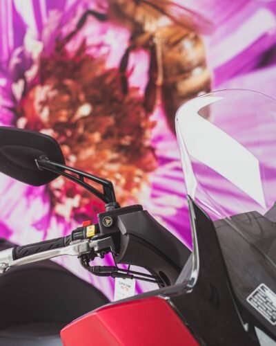 Detalle de una moto sobre fondo magenta
