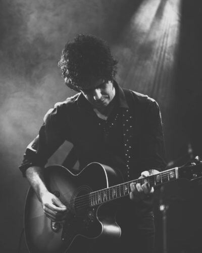 Guitarrista en blanco y negro sobre un escenario