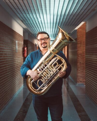 Retrato de un músico con tuba en un pasillo